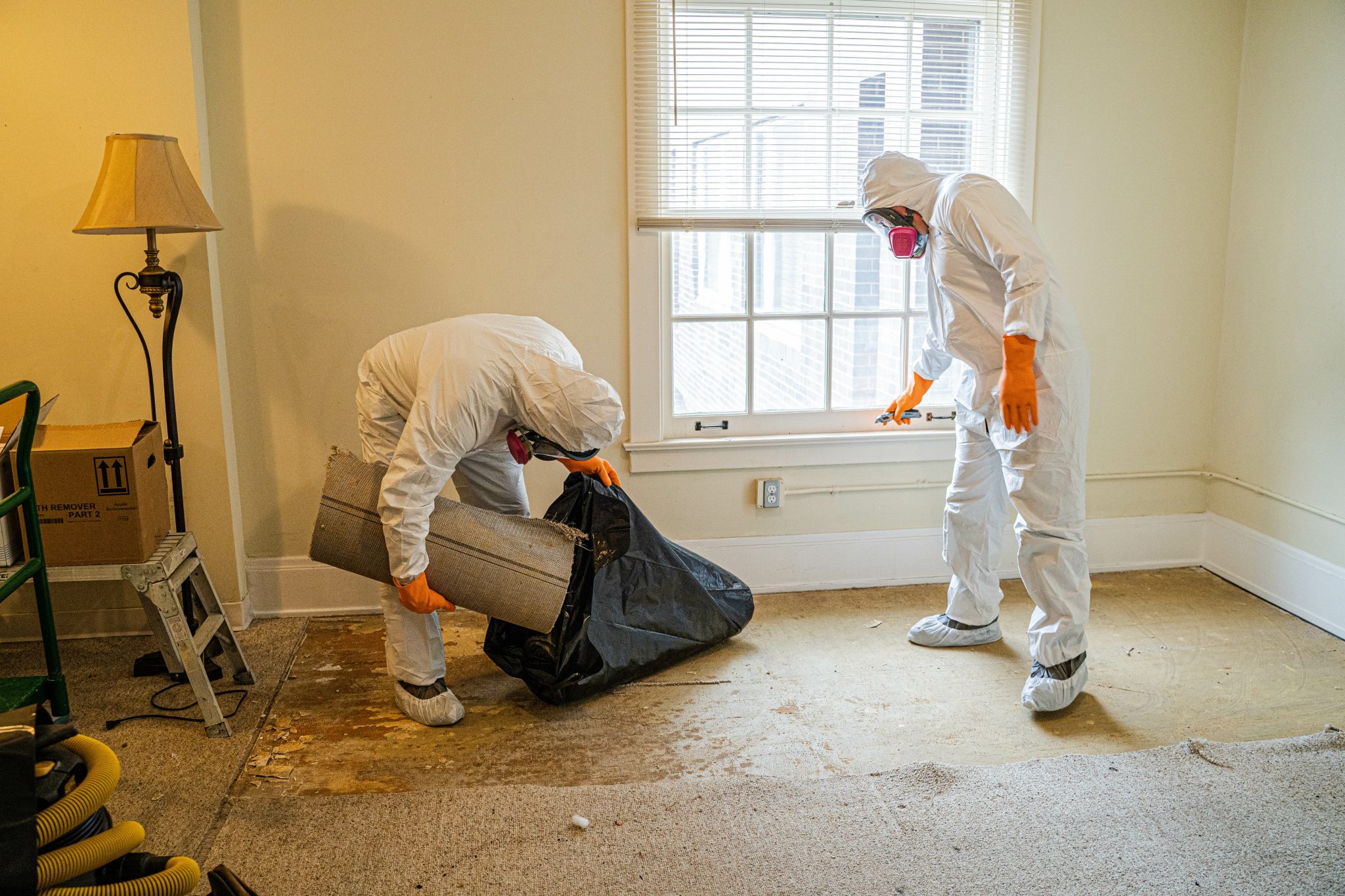 two people in hazmat suits cleaning
